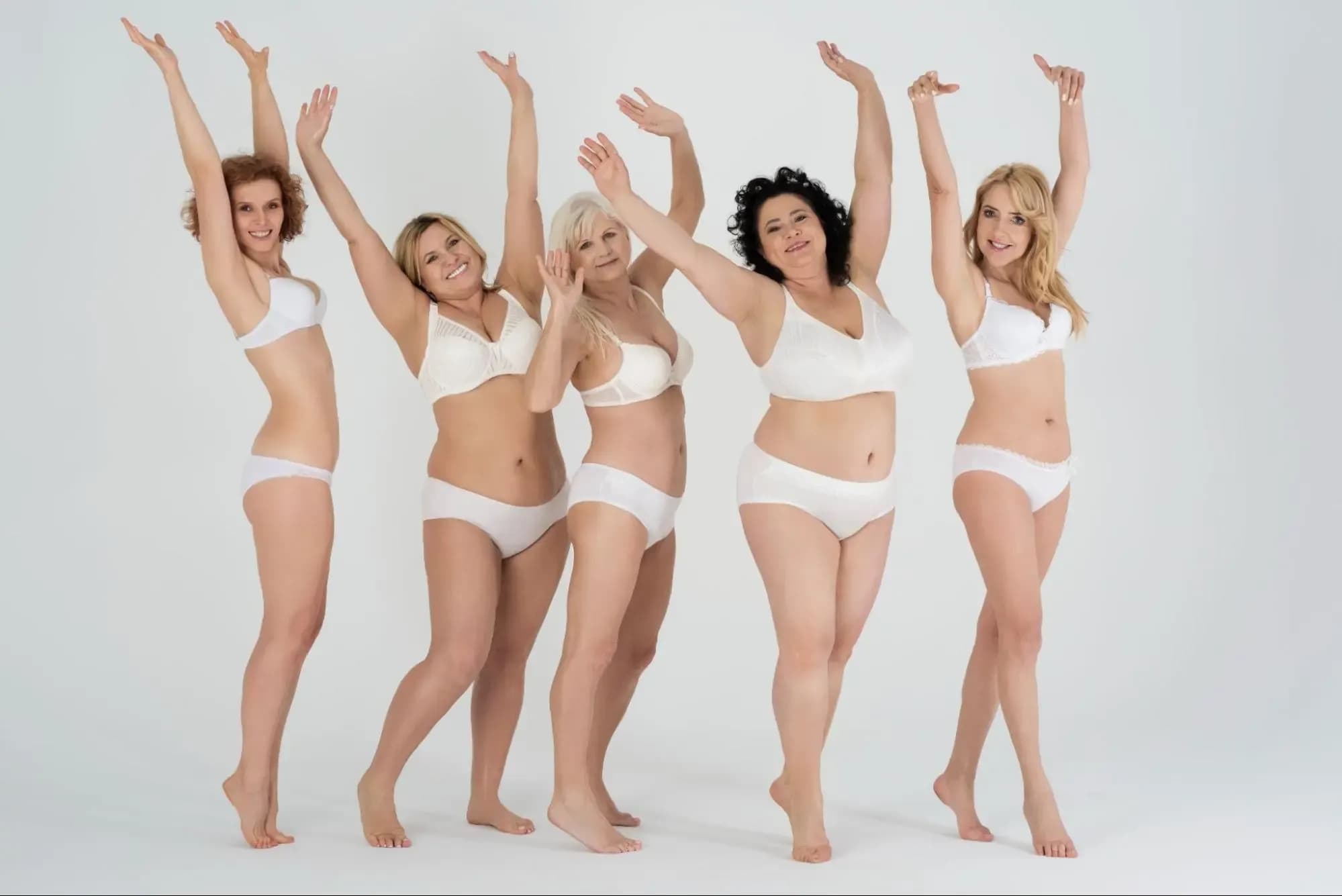 Group of diverse women confidently posing in white lingerie, promoting body positivity and the results of fat-dissolving injections.