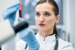 Medical professional examining PRP vial for vampire facial treatment.